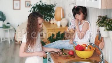 小女孩在厨房的木板上割黄瓜，姐姐坐在桌子上，慢动作